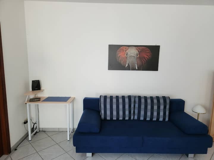 Pequeña área de trabajo para computadoras portátiles y sofá cama, opcional para una tercera persona.