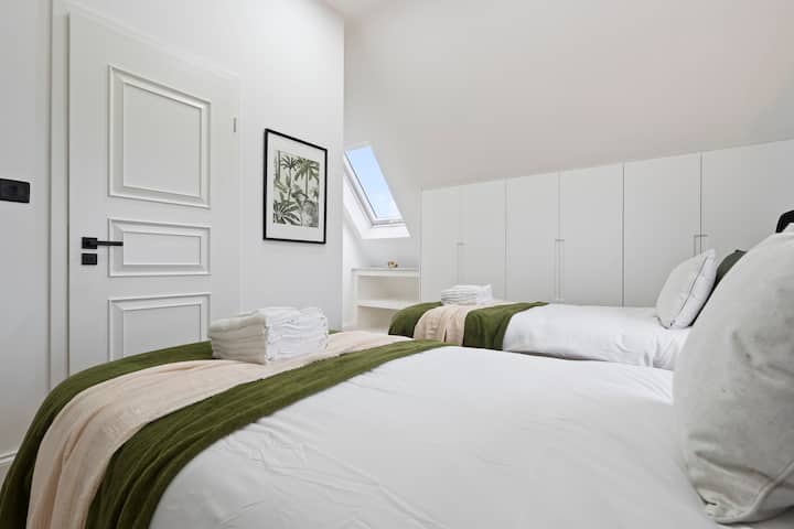 Udobni kreveti za jednu osobu s krovnim prozorom i dovoljno prostora za odlaganje.