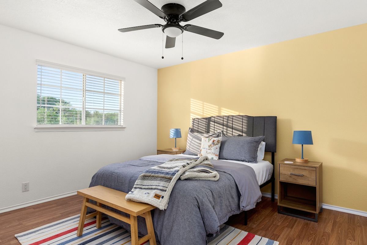 تحتوي غرفة النوم المبهجة هذه على سرير كبير مريح وجدار أصفر نابض بالحياة والكثير من الضوء الطبيعي - وهو مثالي لإقامة مشرقة ومريحة.