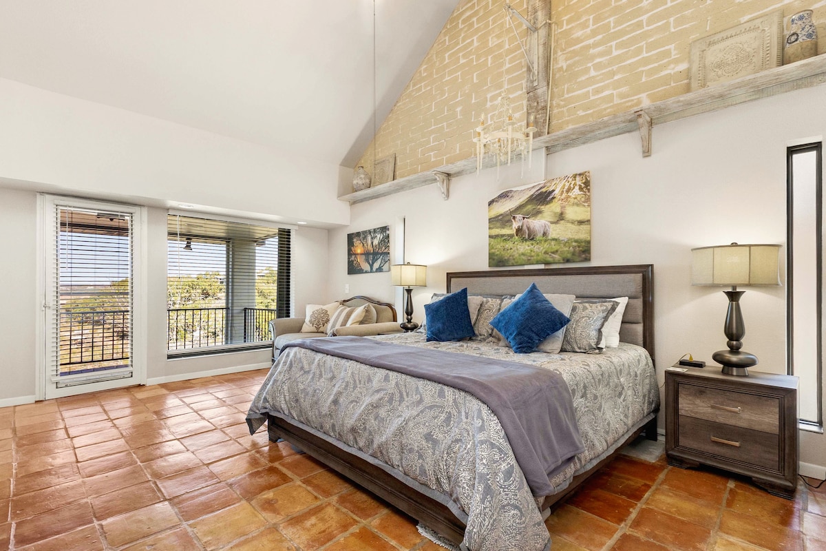 חדר השינה הראשי מרווח ומאוורר, וכולל ספה נעימה ליד החלון הרחב שמסביבו נוף עוצר נשימה לאגם, מקום מפלט אידיאלי למנוחה ורגיעה.