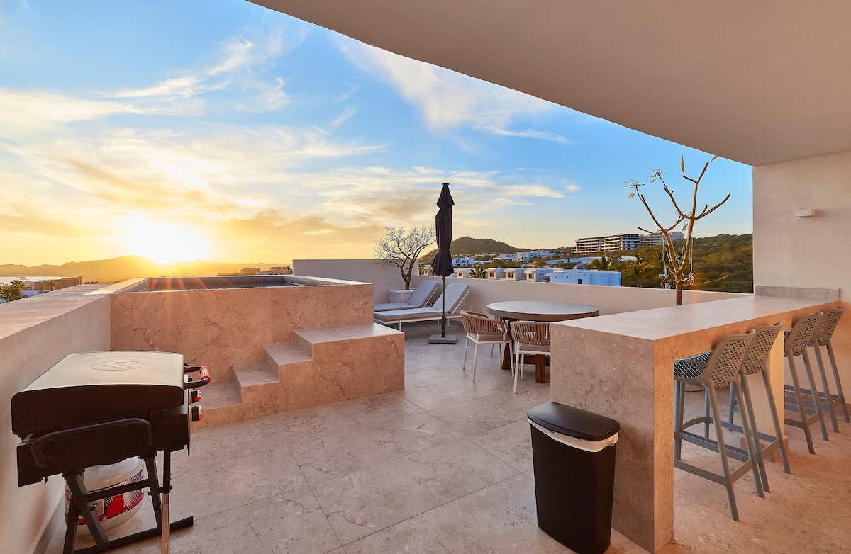 A spacious rooftop terrace features a private splash pool with built-in seating, a dining table for six, and a bar area with four stools. The scene includes a stunning sunset view, enhancing the terrace's modern design and inviting atmosphere.