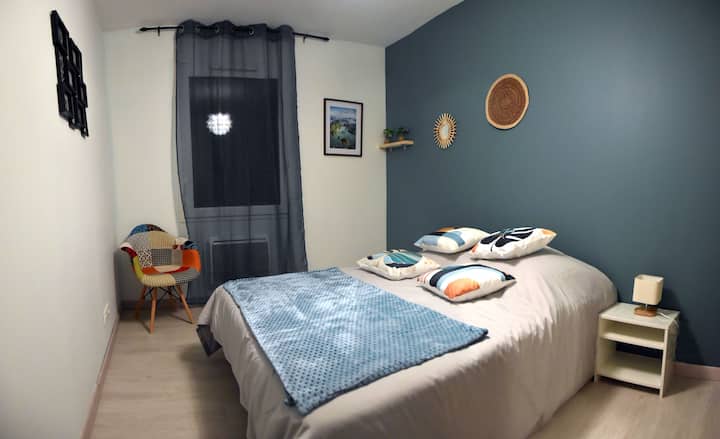 Habitación con un ambiente suave y relajante con pared azul pato, ropa de cama cómoda y decoración de pared de diseño. Ideal para los viajeros que buscan tranquilidad y comodidad en una casa de vacaciones en Savasse. Perfecta para relajarse en Drôme provenzal