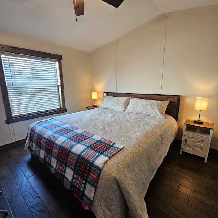 Spálňa s manželskou posteľou King s veľkou inteligentnou televíziou, písacím stolom a šatníkom.