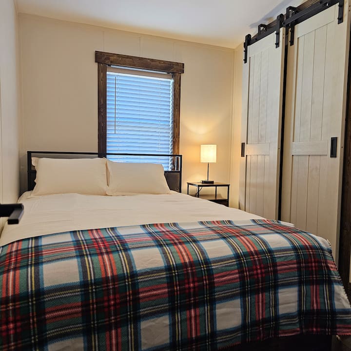 Manželská posteľ s veľkou inteligentnou televíziou a šatníkom.