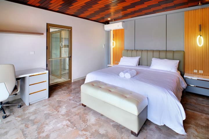 חדר השינה האלגנטי הזה משלב נוחות מודרנית עם מגע של יוקרה. מיטת קטיפה עם מצעים לבנים נקיים משולבת עם מבטאים מעץ חם ותאורה רכה, ואילו פינת עבודה אלגנטית ועיצוב מינימליסטי משלימים את האווירה השלווה. ✨