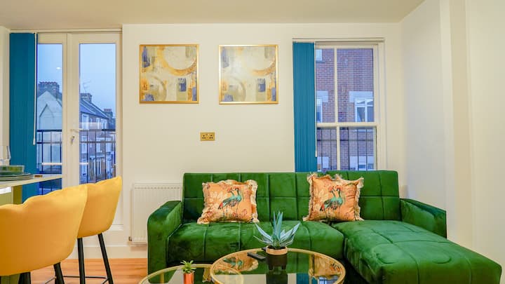 ห้องนั่งเล่นที่สว่างและอบอุ่น มีที่นั่งสบาย เตียงโซฟา และทีวีจอแบน ที่พักนี้ได้รับการออกแบบมาเพื่อการพักผ่อนด้วยแสงสว่างอบอุ่นและบรรยากาศที่อบอุ่นเหมาะสำหรับการผ่อนคลาย การพบปะสังสรรค์ หรือเพลิดเพลินกับคืนชมภาพยนตร์ที่เงียบสงบ