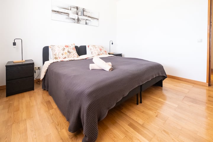 [Dormitorio 3] Armario con perchas y cajones, silla, 2 camas para 1 persona y enchufe junto a cada cama. A tu izquierda tienes un gran ventanal con vistas y cortinas y persianas . 