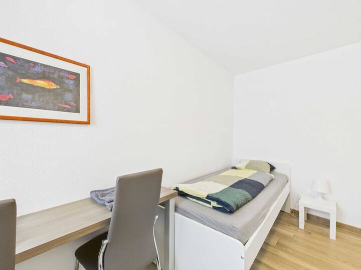 ห้องนอนประกอบด้วยเตียงเดี่ยวสองเตียงและพื้นที่ทำงานให้สภาพแวดล้อมที่ใช้งานได้จริงและหลากหลาย เหมาะสำหรับเด็กหรือผู้เข้าพักผสมผสานความสะดวกสบายสำหรับการพักผ่อนและคุณลักษณะสำหรับสตูดิโอหรือกิจกรรมอื่นๆ