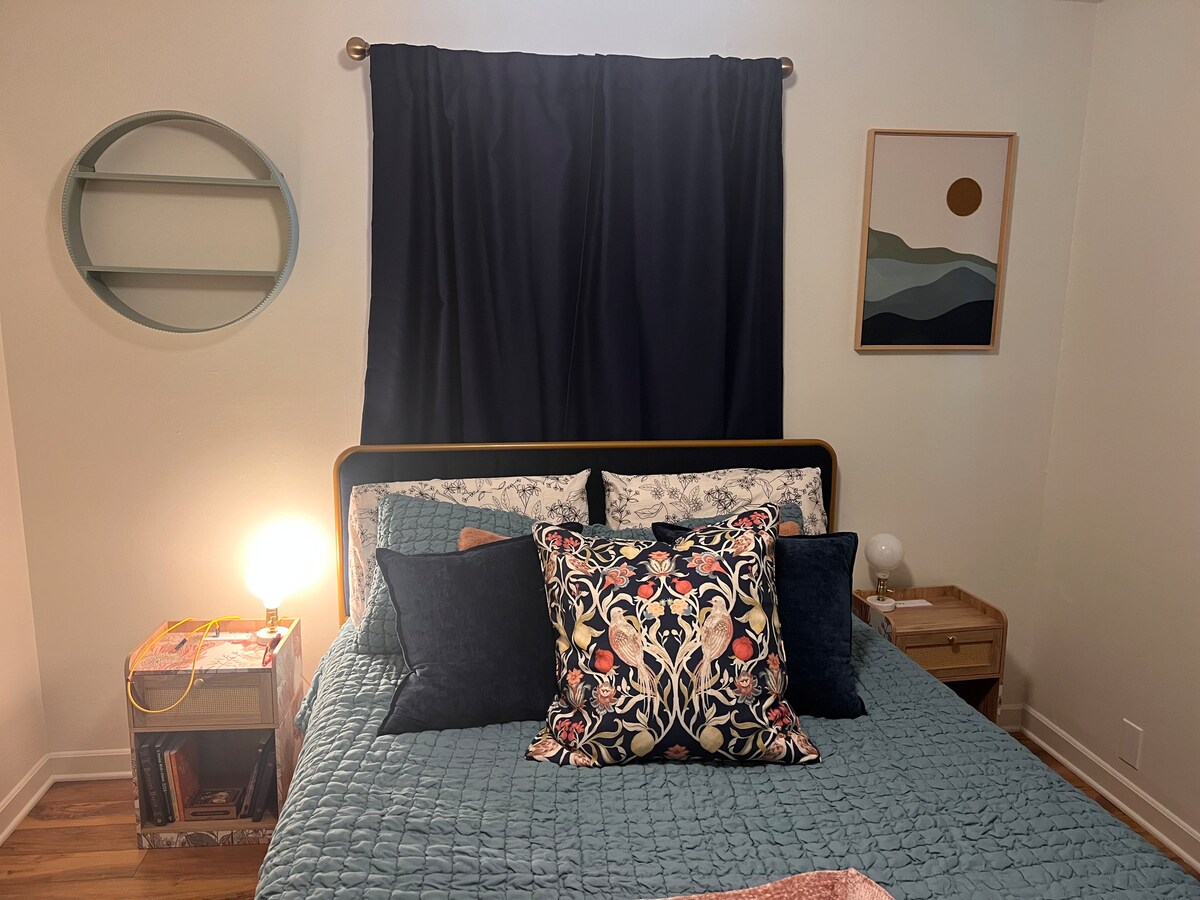 Დედოფლის ზომის საწოლი უამრავი ბალიშით.