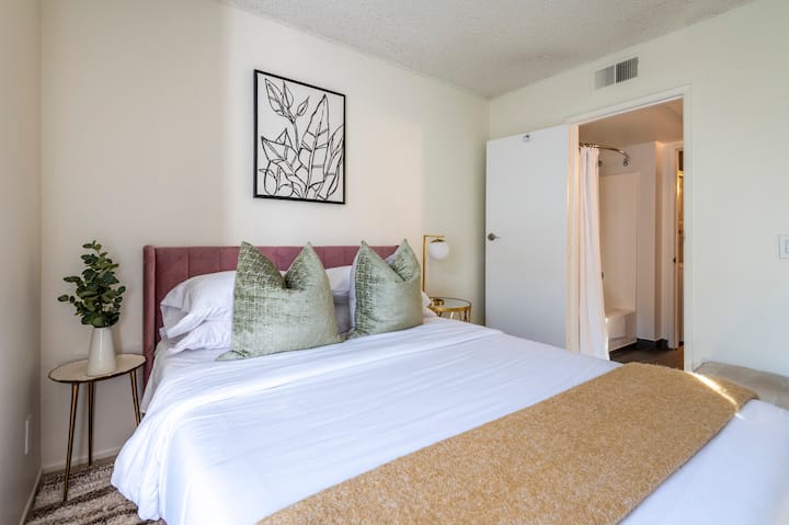 Profitez d'une nuit de sommeil paisible dans cette chambre chic avec un lit en velours moelleux, des accents verts doux et un éclairage chaleureux. La décoration élégante et la salle de bains privative en font une retraite parfaite pour le confort et la commodité.