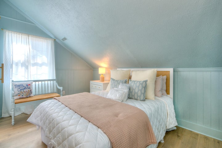 Upstairs bedroom w/ queen bed and bench seating.
