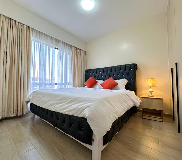 להירגע בחדר השינה הראשי השקט עם מיטת קינג סייז נוחה ותאורה טבעית רכה עם נוף עוצר נשימה לעיר.