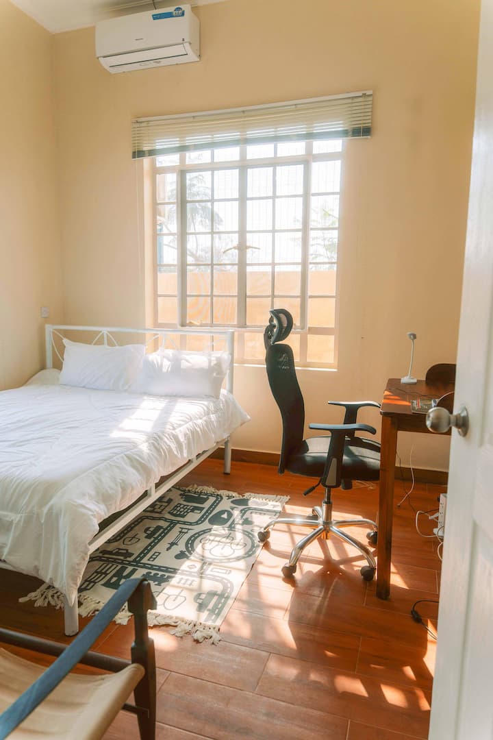 Détendez-vous dans le confort : des oreillers moelleux, des draps frais et une ambiance relaxante font de cette chambre votre retraite Dodoma. De plus, il y a un espace de travail pratique pour travailler.