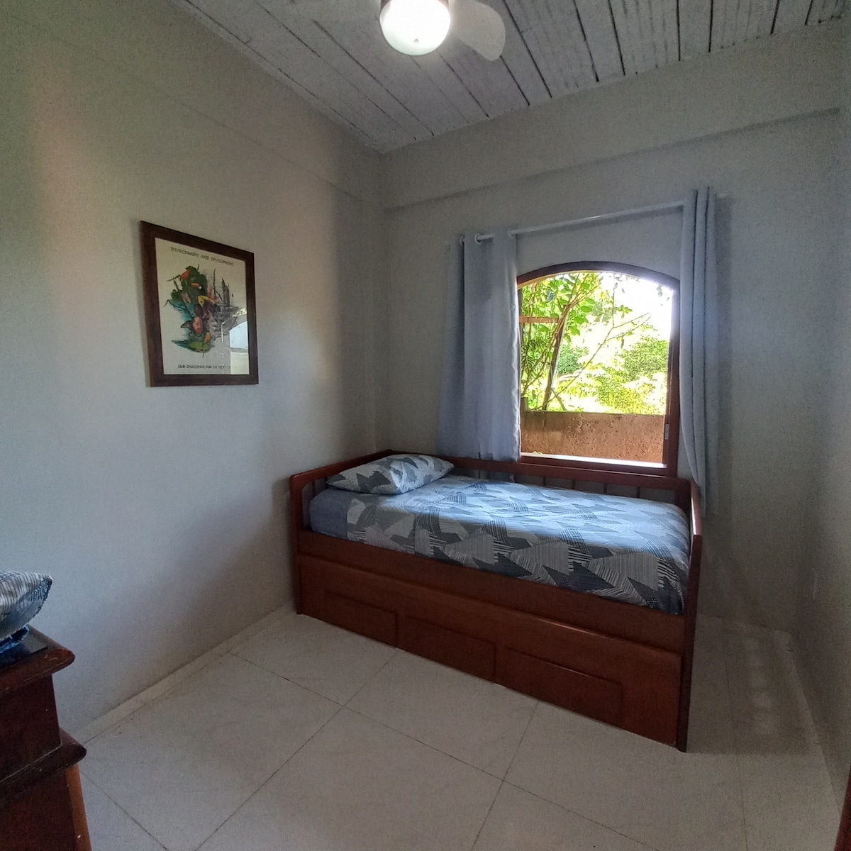 Habitación con dos camas, ventilador de techo y muebles para guardar maletas y guardar objetos

