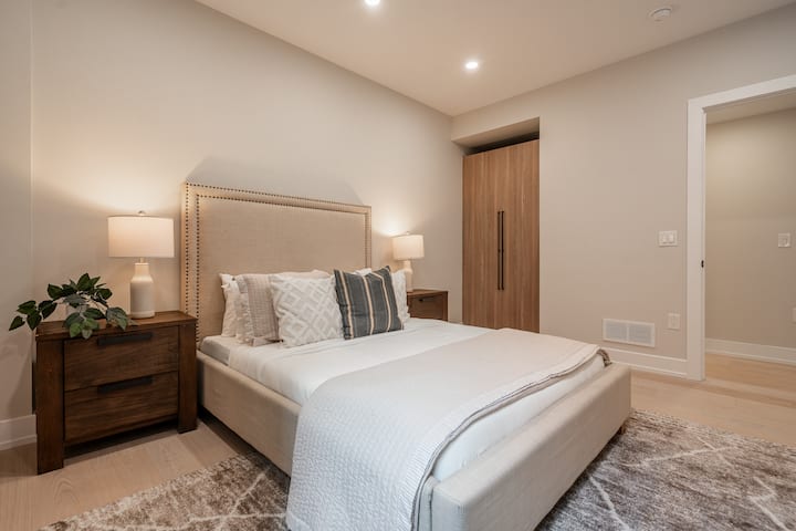 Útulná posteľ s mäkkou posteľnou bielizňou a štýlovými vankúšmi, ktorá vytvára príjemnú a pokojnú atmosféru.