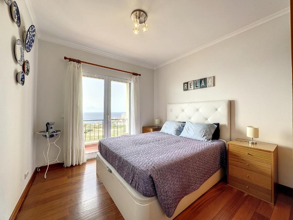 Quarto com cama de casal com vista aberta para a praia/mar.