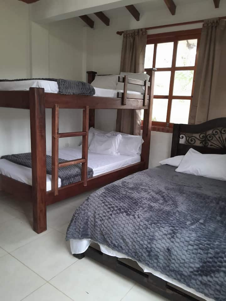 Habitación en primer piso, con cama doble, y camarote dobles, con lencería de lujo para un descanso reparador