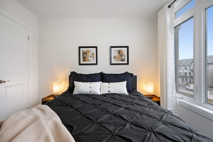 ห้องนอนที่อบอุ่นมีเตียงควีนไซส์หรูหราไฟข้างเตียงและการตกแต่งที่อบอุ่น