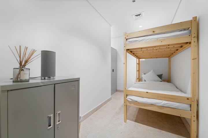 התמונה מציגה חדר לימוד שעבר טרנספורמציה בחוכמה, עכשיו חלל נעים עם מיטת קומתיים מסוגננת, שמתאימה בנוחות לשני אנשים.