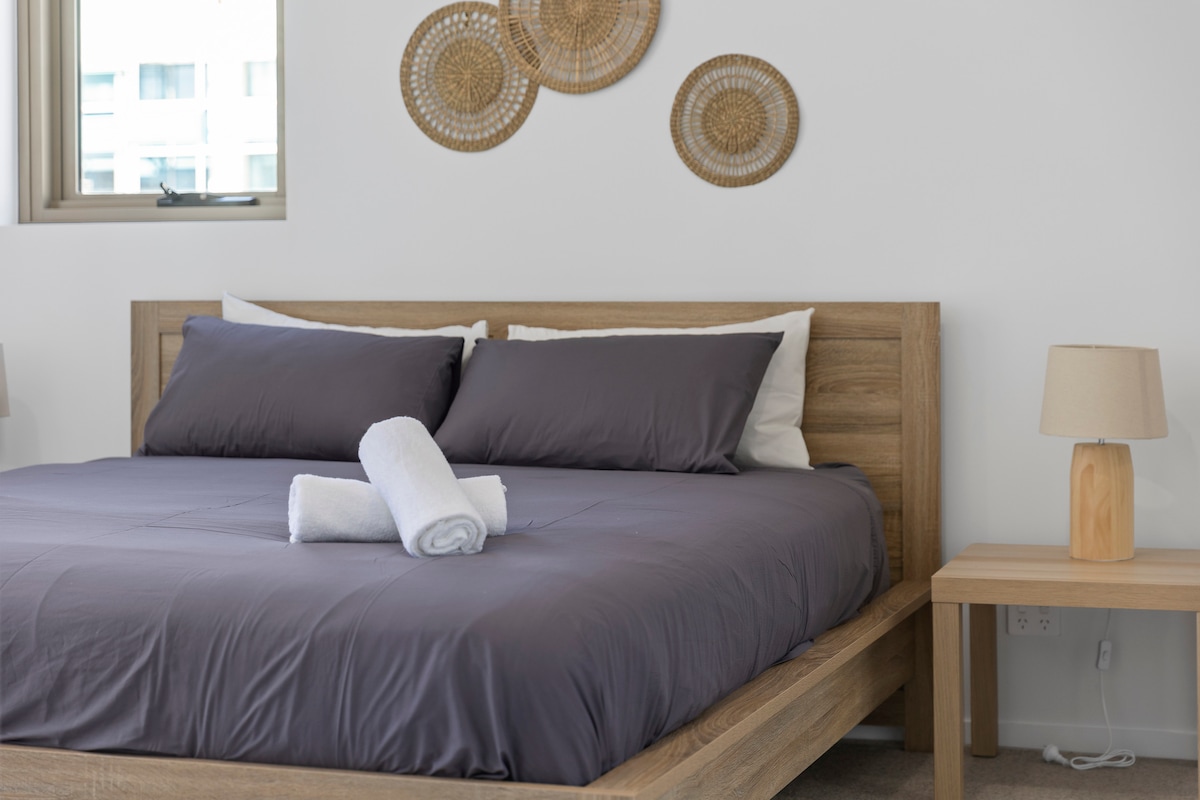 Relájate en nuestro dormitorio sereno, donde una lujosa cama tamaño queen y una suave iluminación preparan el escenario para una noche de sueño reparador. La decoración de buen gusto, incluida una obra de arte mural única, agrega un toque de elegancia a tu santuario personal.