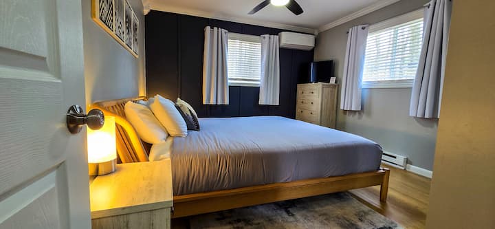Bedroom Retreat: Relax in this stylish room with a plush bed, bright windows, and modern decor!