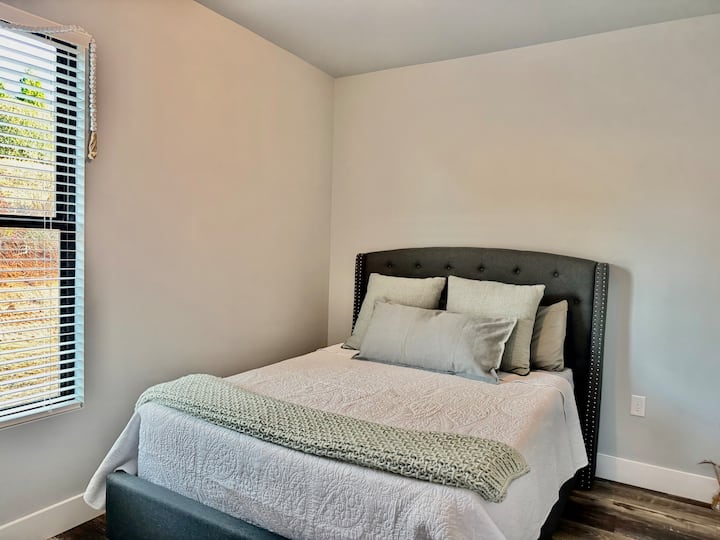 Cómoda cama tamaño queen con manta adicional en la cama y una en el armario.