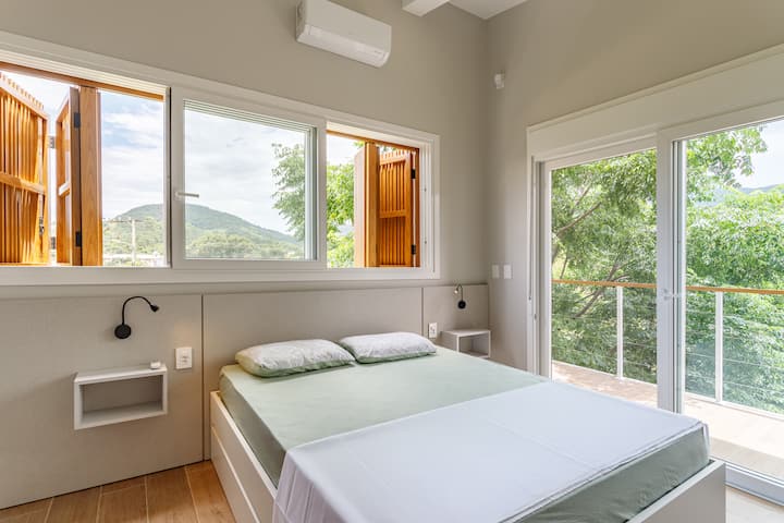 Suíte voltada para os fundos da casa com sacada, ar condicionado, 1 Cama queen e 2 camas auxiliares de solteiro, além de ducha pressurizada com aquecimento a gás no banheiro.