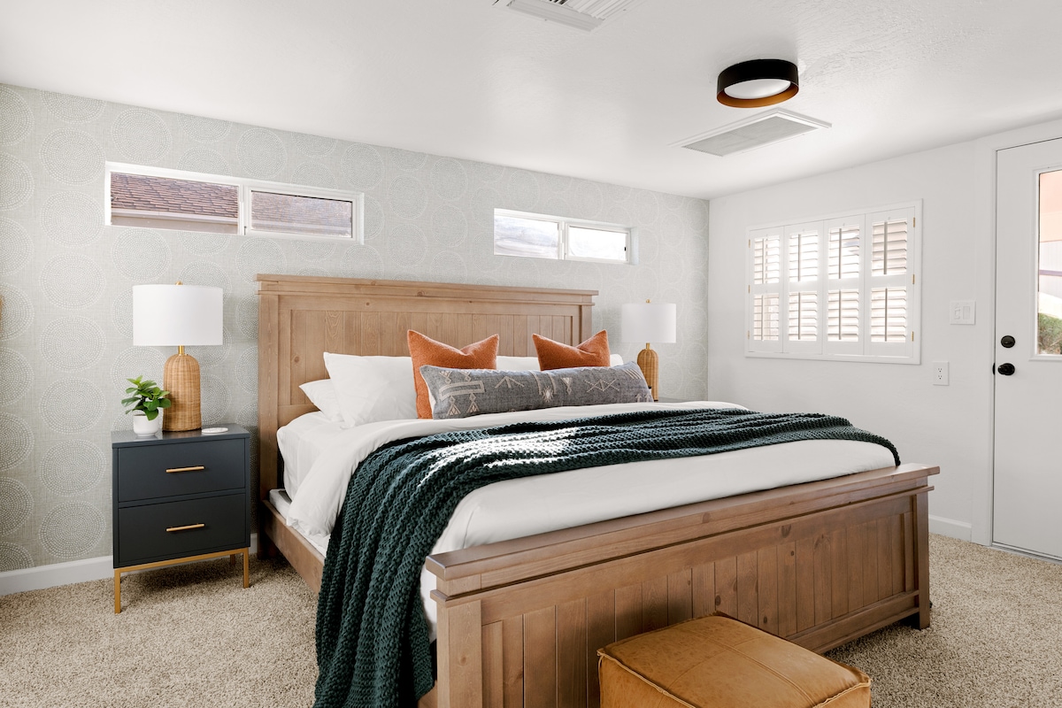 El lujoso dormitorio principal cuenta con una cama tamaño king, un baño privado y un televisor de pantalla plana. Un espejo de cuerpo entero y una entrada privada al patio trasero agregan comodidad y comodidad adicionales.