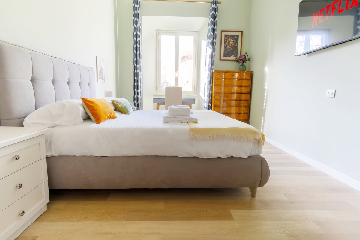 Elegantná izba s manželskou posteľou a čalúneným čelom, písacím stolom, rozťahovacou samostatnou posteľou a inteligentnou satelitnou televíziou.