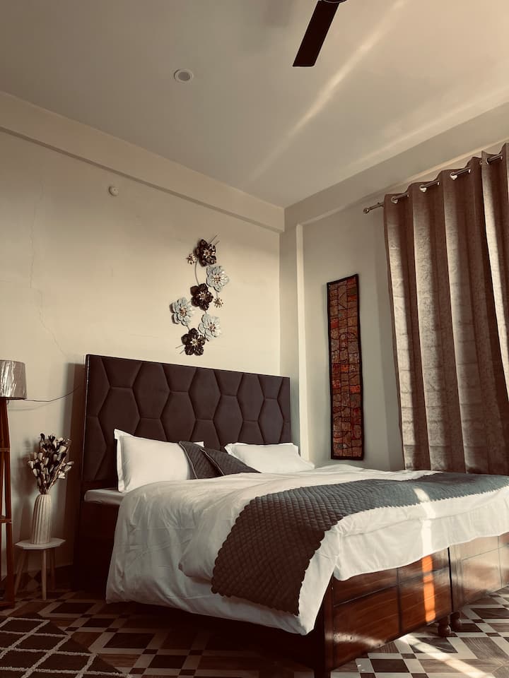 Madhuban Room 1 – Prakriti
Boho-themed cozy room with warm lamp lighting.
 Comes with a personal kitchen, induction & kettle.
 Attached bathroom + a peaceful outdoor gallery.