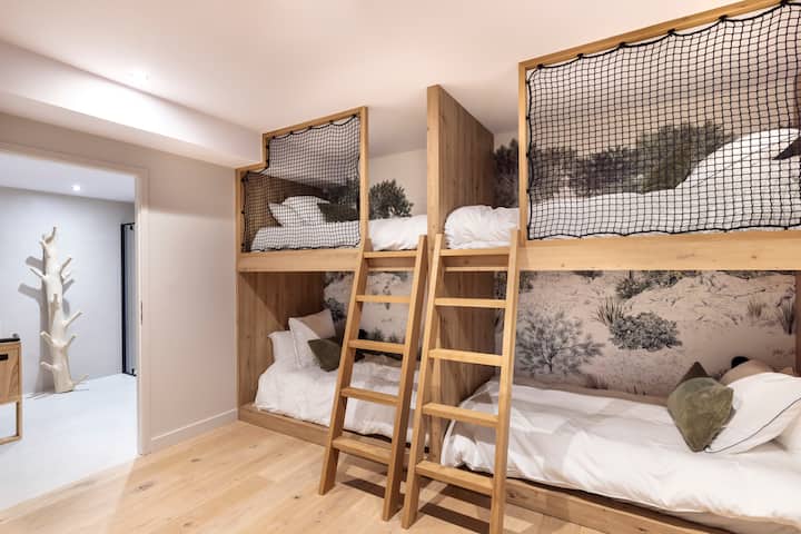 Chambre composé de 4 lits simples, au sous-sol, avec une fenêtre et accès à une cour anglaise. Salle de bain privative avec baignoire et douche. Et WC séparé