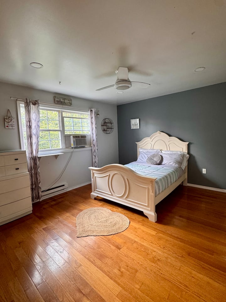 Ნათელი საძინებელი სრული ზომის საწოლით, კომოდით, ორკარიანი კარადით, ჭერის ვენტილატორითა და ფანჯრის სიმყუდროვით და ბუნებრივი განათებით.