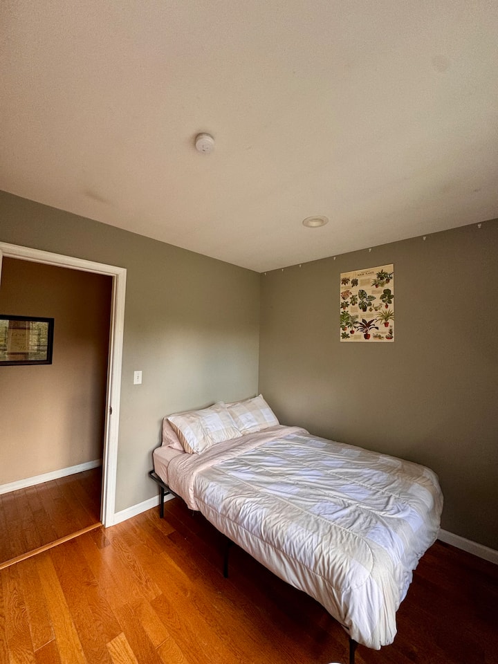 Მყუდრო საძინებელი სრული ზომის საწოლით, სარკისებური კარადით, პორტატული კონდიციონერითა და დიდი ფანჯრებით, რომლებსაც აქვს ბუნებრივი სინათლე - მარტივი და დასასვენებელი სივრცე დასვენებისთვის.