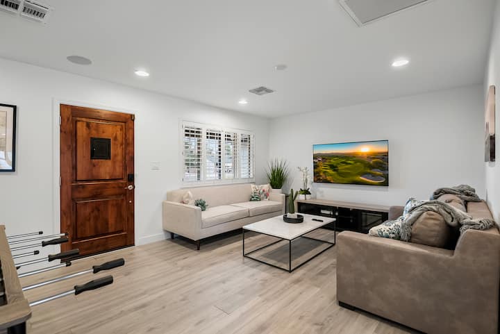 Salón luminoso con lujosos sofás, un televisor de pantalla grande