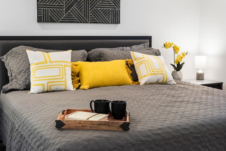 Amplia cama tamaño king con un colchón de alta calidad y vibrantes detalles amarillos para la máxima comodidad