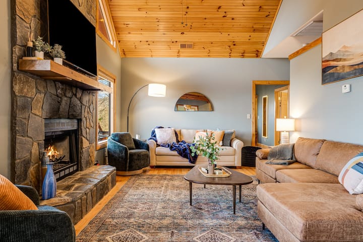 Bright and inviting living room with chic decor, cozy fireplace, and a pull-out couch that sleeps 2 comfortably. Perfect for lounging, game nights, or relaxing after a day of adventure.