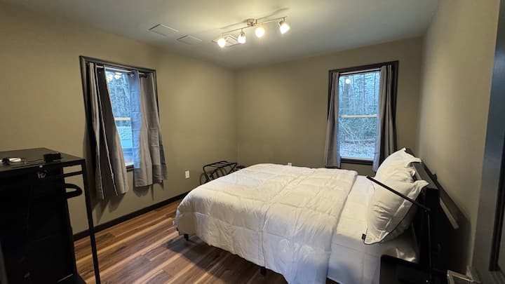 Chumba cha 3 cha kulala cha wageni kina chumba cha kulala cha malkia na upande wa chumba kuna sitaha ambayo ina beseni la maji moto la kuni