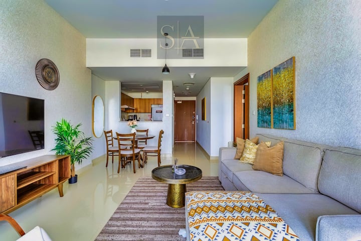 Banesë me plan të hapur me një divan krevat të rehatshëm, televizor inteligjent dhe dekor elegant. Zona e ngrënies ka katër vende, të përsosura për vakte ose punë. Një kuzhinë e pajisur plotësisht me pajisje moderne e bën gatimin të lehtë. Thekse të kujdesshme, ndriçimi i ngrohtë dhe bimët shtojnë bukuri.