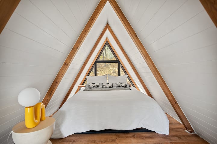 Charming A-Frame Bedroom: Discover stunning views and stylish decor for ultimate relaxation!