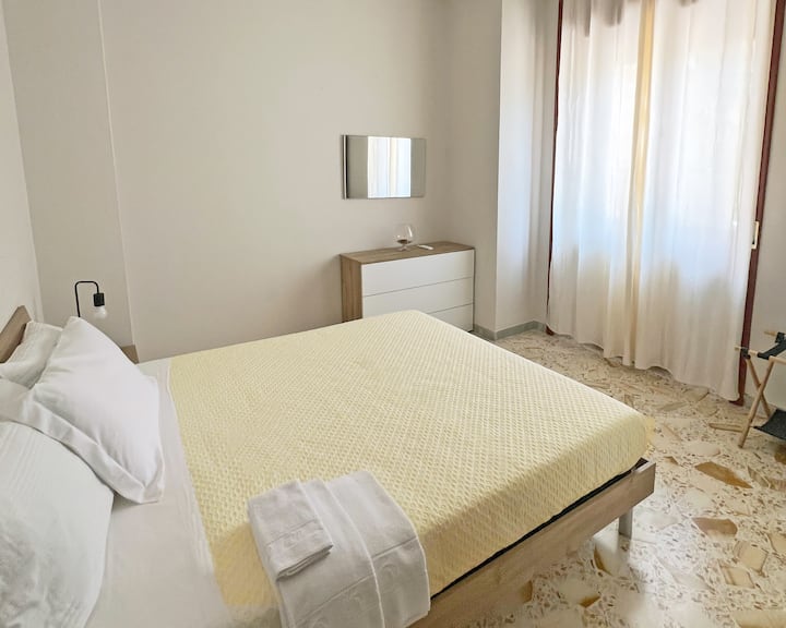 Dormitorio doble 3, con ventana, aire acondicionado, armario con espejos completos, cómoda, mesitas de noche, ropa de cama y almohadas adicionales incluidas.