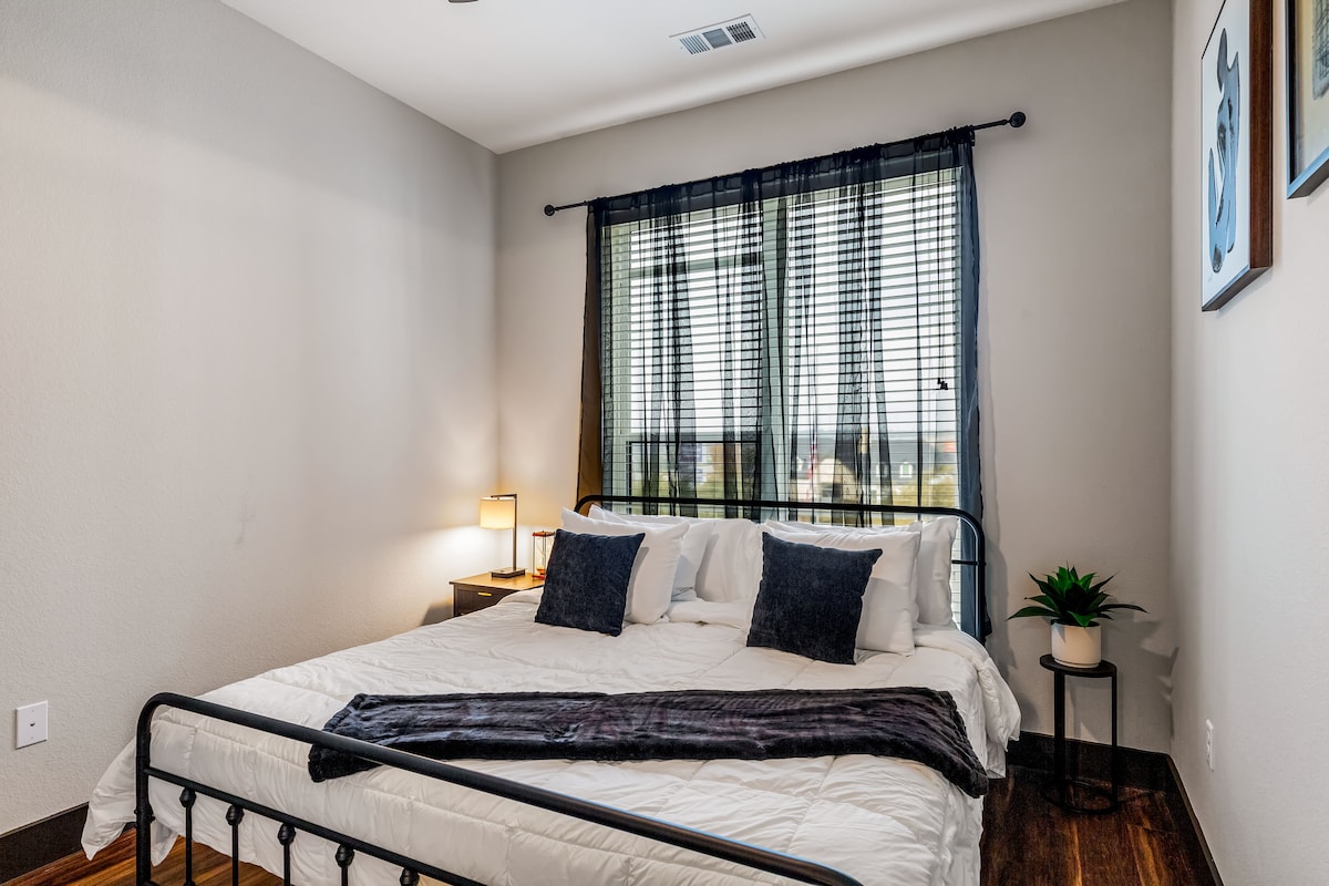 غرفة نوم مريحة بإضاءة ناعمة وسرير مريح بحجم كوين.