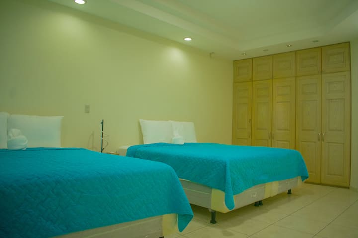 Chambre spacieuse et confortable, équipée d'un lit King luxueux et d'un lit Queen, parfaite pour accueillir plusieurs personnes et assurer un repos réparateur pour tous.