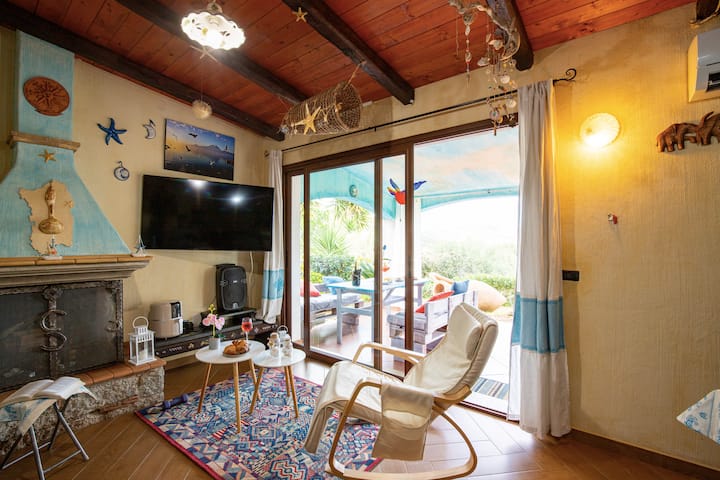 Obývacia izba s rozkladacou pohovkou, televízorom a výhľadom na záhradu s výhľadom na more.