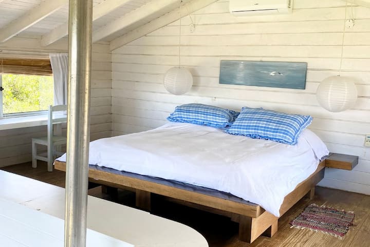 Chambre principale dans la maison d'hôtes avec vue sur l'océan et le phare.  Doté d'un lit double queen size, d'un grand placard, d'un bureau et d'une chaise.