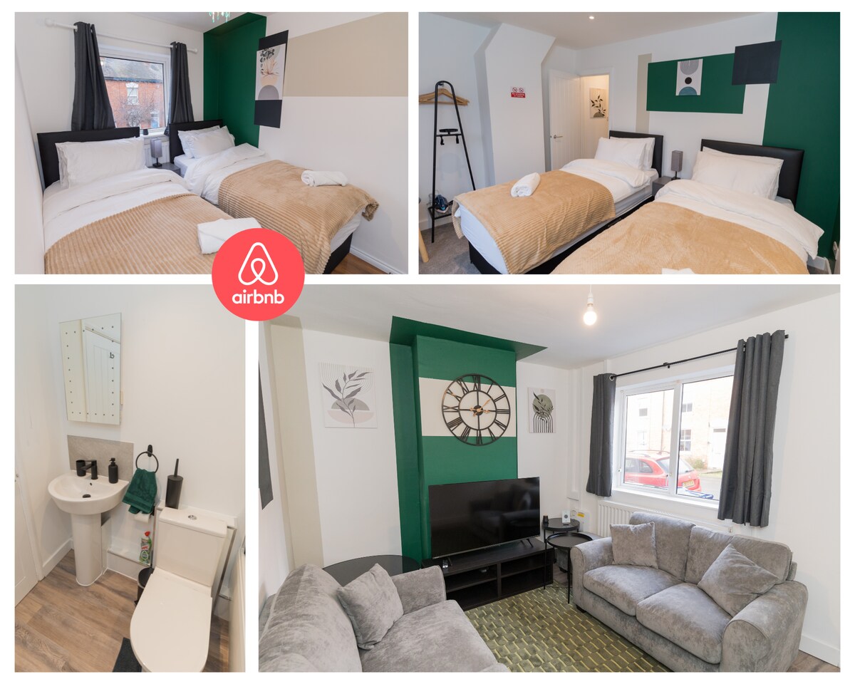 Two guest bedrooms are featured, each with single beds dressed in neutral linens. The living area includes a comfortable couch set facing a TV, with a decorative clock on the wall. A modern bathroom is visible, equipped with essential amenities.