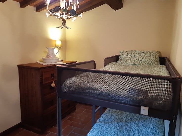 Habitación pequeña con una litera ideal para niños. La habitación incluye una cómoda y un pequeño armario. La habitación no tiene puerta