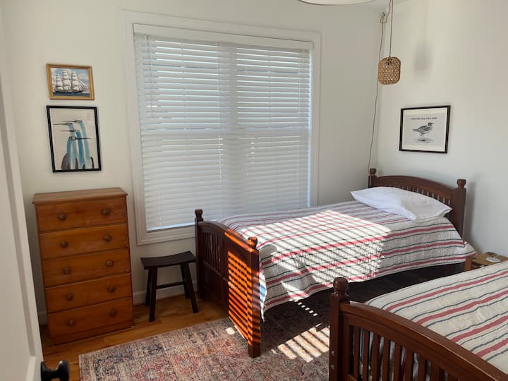 Este dormitorio luminoso y soleado está ubicado en el nivel principal.  Cuenta con dos camas individuales.  Hay un medio baño cerca de este dormitorio en el piso principal.  