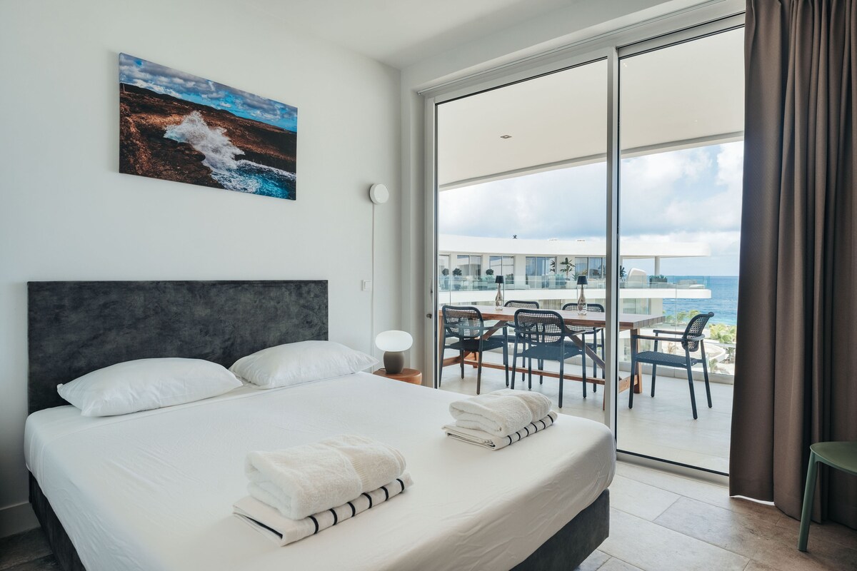 חדר השינה הנוח הזה כולל מיטת קינג-סייז, מצעים נקיים ונוף יפהפה לאוקיינוס. תוכלו ליהנות מהמרפסת המרווחת והאור הטבעי הזורם דרך דלתות הזזה גדולות.