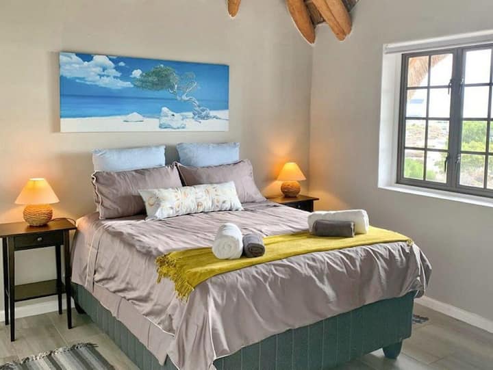 Amplio segundo dormitorio con una cómoda cama, armarios empotrados y una gran ventana con vistas al mar. Disfruta de la luz natural, el aire fresco de la costa y los relajantes sonidos del océano para una estancia verdaderamente relajante.