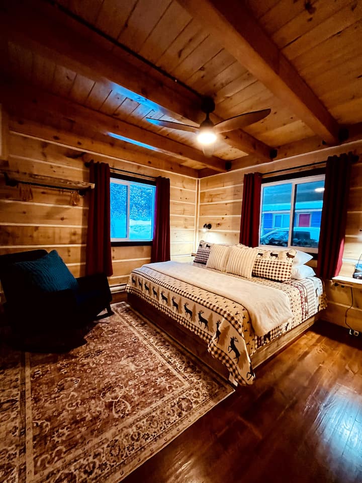 Our main floor master bedroom features a king size bed, blue rocking chair and ceiling fan. We also provide a white noise machine, charging station and blackout curtains to help in getting a good night's sleep.